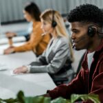 multicultural call center operators with headsets at workpalce in office